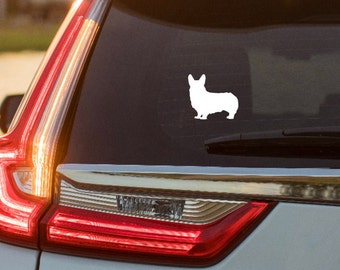 May include: White corgi dog silhouette sticker on a car window. The decal shows a simple outline of a corgi, a breed known for its short legs and long body. The car's taillight is visible.