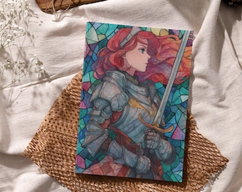 May include: A colorful illustration of a female knight with red hair, clad in silver armor, holding a sword. The background is a stained-glass design with various colors. The artwork is on a notebook, resting on a brown paper.