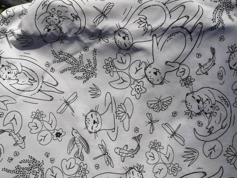 May include: Black and white fabric with a repeating pattern of otters holding each other, lily pads, dragonflies, and fish. The fabric has a light gray background.