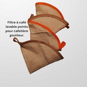 Pode incluir: Três filtros de café reutilizáveis feitos de tecido castanho com guarnição laranja. Os filtros são projetados para uma cafeteira de gotejamento. O texto na imagem diz "Filtre à café lavable pointu pour cafetière goutte à goutte."
