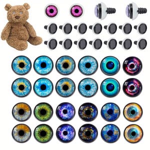 Puede incluir: Un oso de peluche marrón se sienta junto a una variedad de ojos artesanales en diferentes colores y estilos. Los ojos incluyen ojos de plástico transparente con pupilas negras, ojos morados y ojos de vidrio con diseños azules, verdes y galácticos.