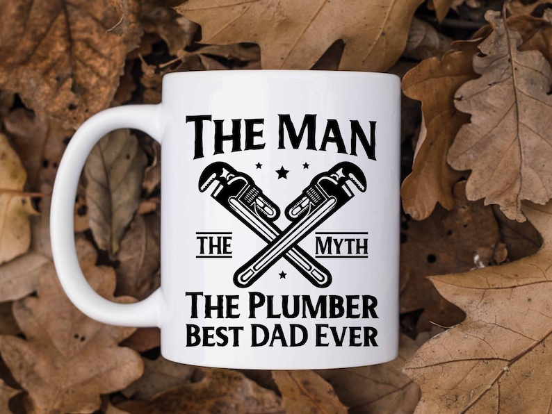 May include: White ceramic mug with a black design. The design features two crossed wrenches with the text "The Man The Myth The Plumber Best Dad Ever".