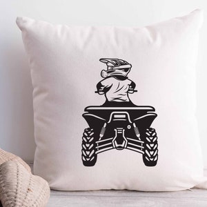 Puede incluir: Ilustraci&oacute;n en blanco y negro de una persona con casco conduciendo un ATV. El ATV tiene cuatro ruedas y un asiento. La persona est&aacute; de espaldas al espectador.