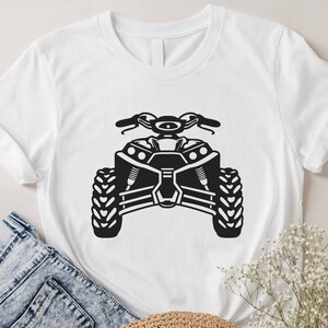 May include: White t-shirt with a black silhouette of an ATV, or all-terrain vehicle.