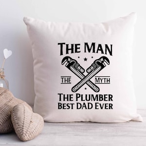 May include: White pillow with black text that reads "The Man The Myth The Plumber Best Dad Ever" with a graphic of two crossed wrenches.