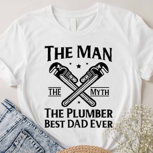 May include: White t-shirt with black text that reads "The Man The Myth The Plumber Best Dad Ever". Two crossed wrenches are above the text.