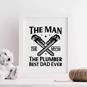 May include: A white framed print with black text that reads "The Man The Myth The Plumber Best Dad Ever". The text is surrounded by a graphic of two crossed wrenches.