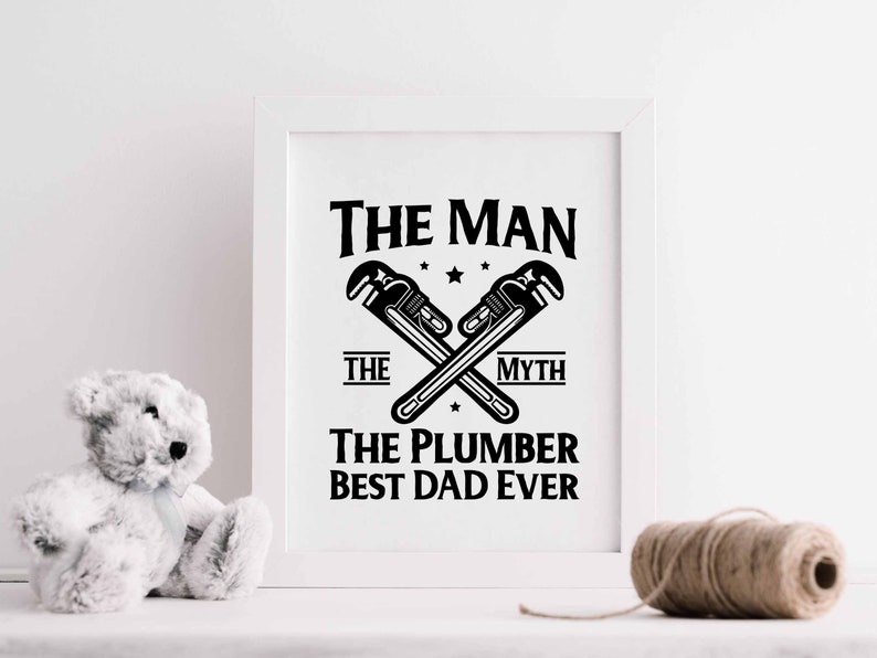 May include: A white framed print with black text that reads "The Man The Myth The Plumber Best Dad Ever". The text is surrounded by a graphic of two crossed wrenches.