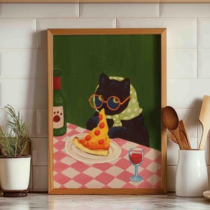 May include: A framed art print depicts a black cat wearing glasses and a scarf, enjoying a slice of pizza and a glass of wine. The cat is seated at a table with a pink and white checkered tablecloth, with a green background.