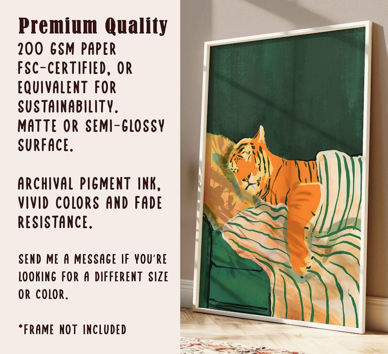 May include: A framed art print featuring an orange tiger resting on a striped pillow and green background. The print has a white border and includes text about the paper quality, ink, and fade resistance.