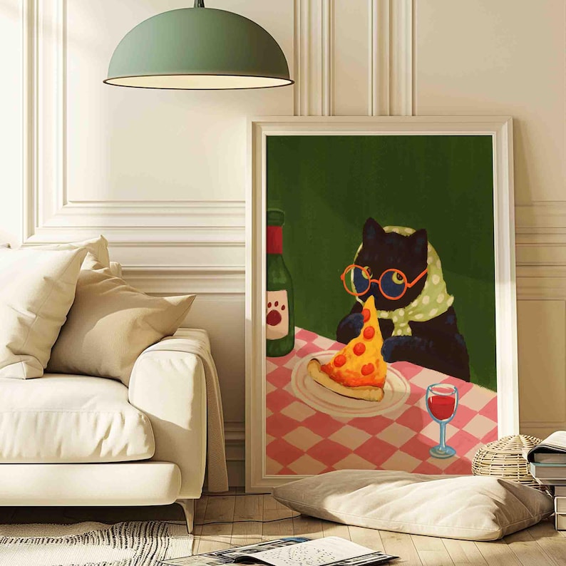 May include: A framed art print depicts a black cat wearing glasses and a scarf, seated at a table with pizza and wine. The table is covered with a red and white checkered tablecloth, and a green bottle with a paw print label is visible.