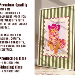 May include: A framed art print with a tiger wearing a pink cowboy hat, set against a pink background with the words "STAY WILD". The print is in a white frame with a green and white striped border. The text on the left side says "Premium Quality".