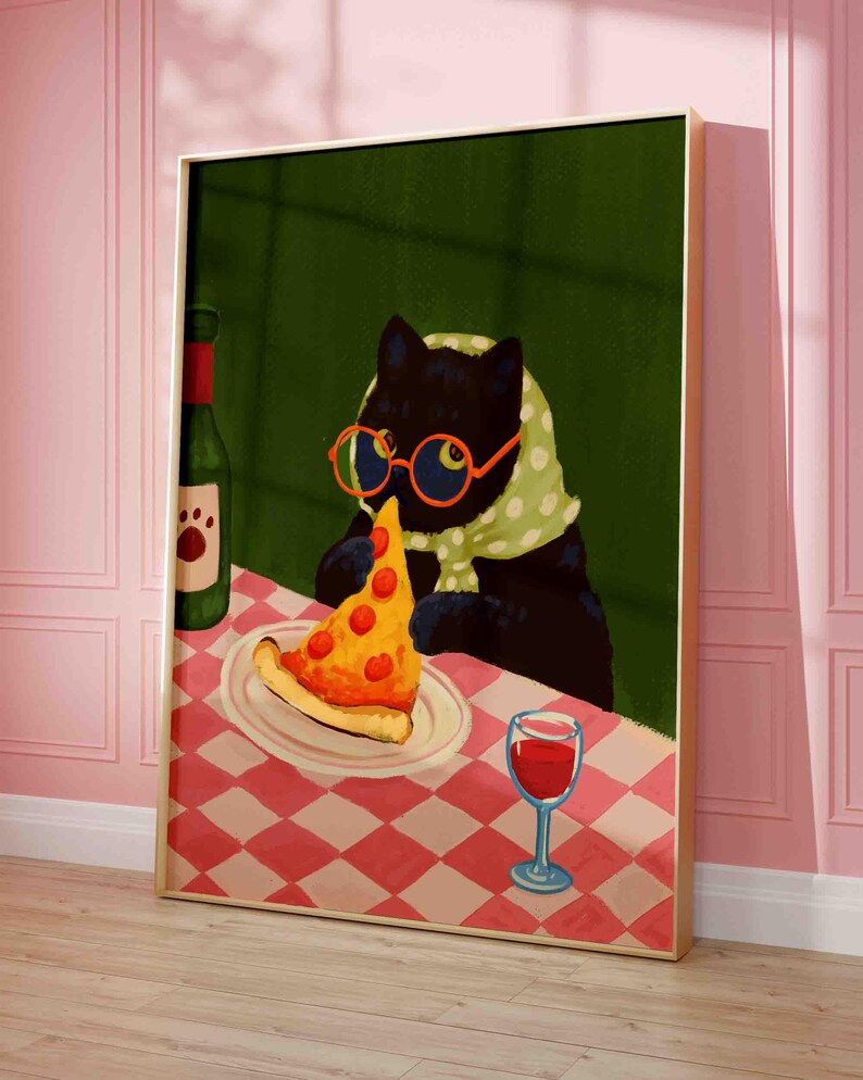May include: A framed art print featuring a black cat wearing glasses and a scarf, enjoying a slice of pizza. A bottle of wine and a glass of red wine are on the table. The table has a red and white checkered tablecloth.