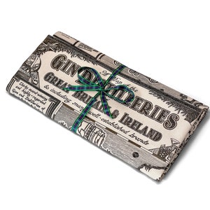 May include: A map of gin distilleries in Great Britain and Ireland, printed on a cream-colored fabric with a black and green ribbon tied around it.