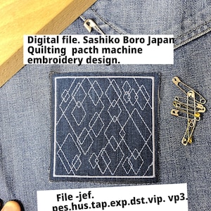May include: A square, dark blue fabric patch with a white geometric design, likely for embroidery. The patch is on a denim background, with text indicating it's a digital embroidery file. Safety pins and a wooden object are also visible.
