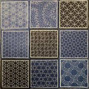 May include: Nine denim squares with different white embroidered patterns. The patterns include a floral design, leaves, circles, hexagons, a puzzle, stars, and a wavy design.