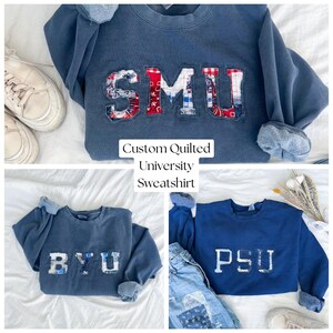 Puede incluir: Un collage de tres sudaderas azules con letras universitarias acolchadas personalizadas. La sudadera superior muestra "SMU" en tela roja, blanca y azul. La sudadera inferior izquierda muestra "BYU", y la inferior derecha muestra "PSU". También se ve el texto "Custom Quilted University Sweatshirt".