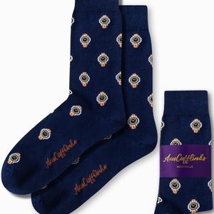 May include: Navy blue socks with a repeating pattern of gold and white watches. The socks have the text "AusCufflinks" in orange script. One pair of socks is folded with a purple band that reads "AusCufflinks AUSTRALIA".