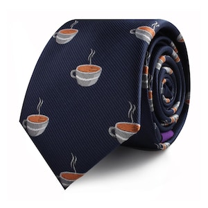 May include: Navy blue necktie featuring a repeating pattern of coffee cups. Each cup is gray with an orange interior and steam rising from the top. The tie is rolled up, showing the pattern on the inside.