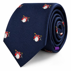 Puede incluir: Una corbata azul marino con un patrón repetitivo de pequeñas baterías rojas con parches blancos y platillos amarillos. La tela tiene una fina textura acanalada diagonal y la corbata está enrollada para mostrar el patrón en la superficie.