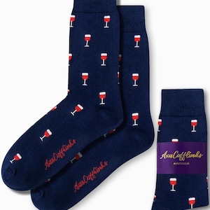 Peut inclure: Une paire de chaussettes bleu marine avec un motif de verre à vin rouge. Les chaussettes sont pliées et affichées avec une petite étiquette qui indique "Aus Cufflinks AUSTRALIA".
