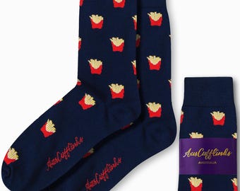 Puede incluir: Un par de calcetines azul marino con un patrón de papas fritas rojas y amarillas. Los calcetines están empaquetados con una etiqueta púrpura y dorada que dice "AusCufflinks AUSTRALIA".