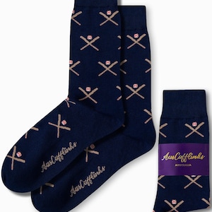 Könnte beinhalten: Marineblaue Socken mit einem Baseballschläger- und Ballmuster. Die Socken haben ein sich wiederholendes Design aus gekreuzten Schlägern und Basebällen in einem beigen Farbton. Der Markenname "AusCufflinks" ist aufgedruckt.