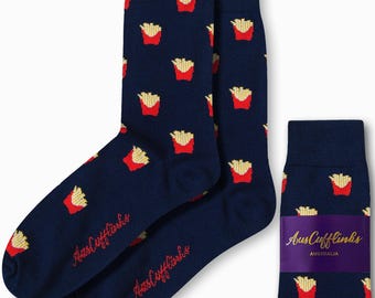 Puede incluir: Calcetines azul marino con un patrón repetido de patatas fritas rojas y amarillas. Los calcetines tienen el texto "AusCufflinks AUSTRALIA" en rojo. Un par está doblado con una etiqueta morada.