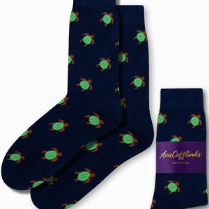 May include: A pair of navy blue socks with a green and brown turtle pattern. The socks are shown with a tag that reads "AusCufflinks AUSTRALIA".