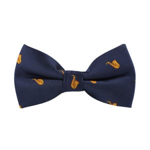 May include: A navy blue bow tie with a repeating pattern of gold saxophones. The bow tie is tied and ready to wear, with a classic butterfly shape. The fabric has a subtle ribbed texture.