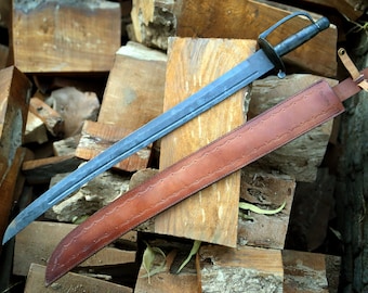May include: A long, curved, blue steel sword with a brown leather scabbard. The sword has a simple handle with a ring for a finger guard. The scabbard has a decorative pattern and a strap.