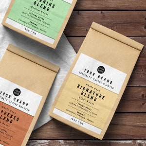 May include: Three brown paper bags with labels for different coffee blends. The labels are white with black text and feature the words "Your Brand" and "Specialty Coffee Roaster". The blends are "Morning Blend", "Signature Blend", and "Presso Blend". Each blend has a description of its tasting notes and origins. The bags are 16 ounces or 1 pound.