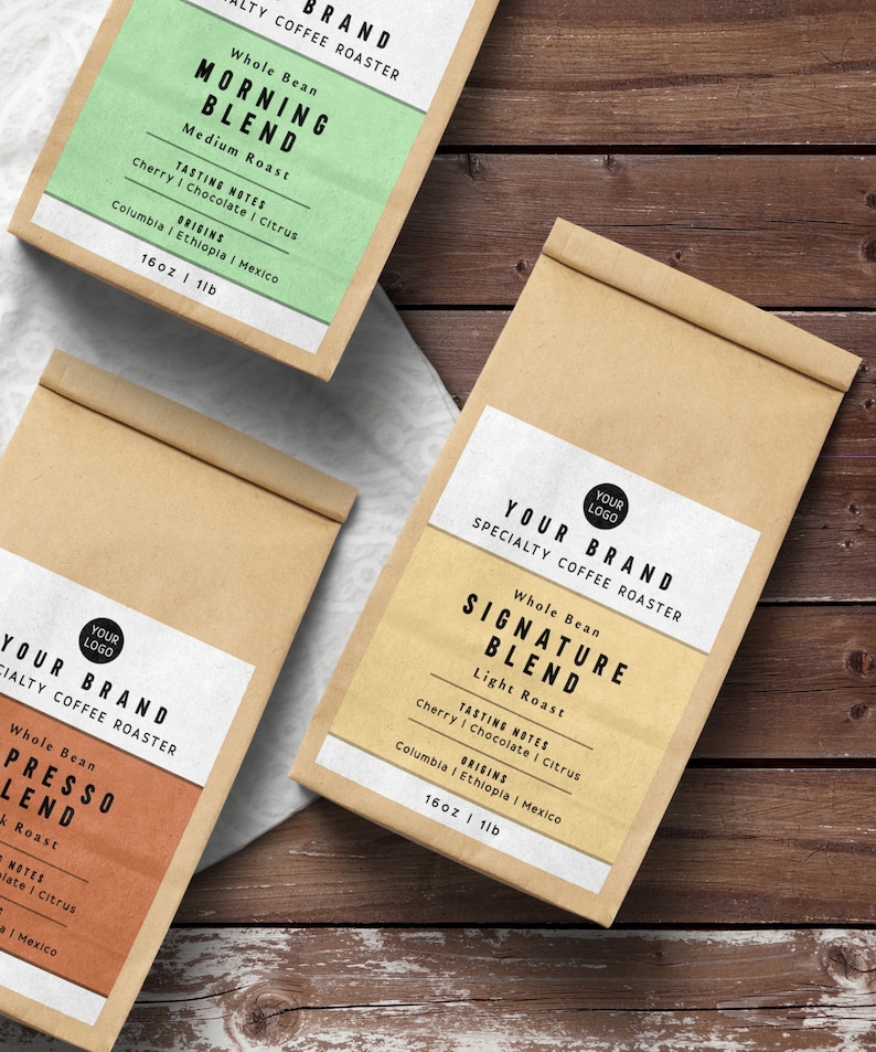May include: Three brown paper bags with labels for different coffee blends. The labels are white with black text and feature the words "Your Brand" and "Specialty Coffee Roaster". The blends are "Morning Blend", "Signature Blend", and "Presso Blend". Each blend has a description of its tasting notes and origins. The bags are 16 ounces or 1 pound.