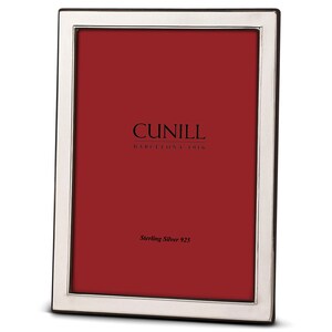 May include: A silver picture frame with a black border. The frame has the text "CUNILL BARCELONA 1916" and "Sterling Silver 925" on the front.