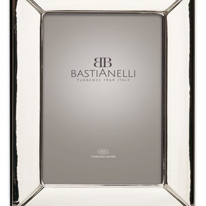 Könnte beinhalten: Ein rechteckiger, polierter Silberbilderrahmen. Der Rahmen hat einen breiten, abgeschrägten Rand und eine glatte, reflektierende Oberfläche. Der Text "BASTIANELLI FLORENCE 1964 ITALY" ist auf der Innenseite des Rahmens aufgedruckt. Die Worte "925 STERLING SILVER" sind ebenfalls aufgedruckt.
