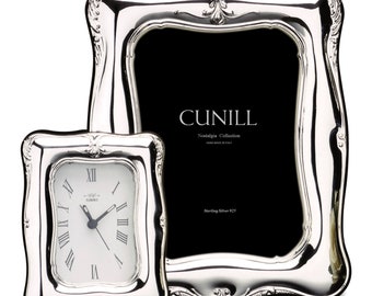 Può includere: Un set di cornice per foto e orologio placcato argento con un design ornamentale. La cornice è più grande dell'orologio e ha uno sfondo nero. L'orologio ha numeri romani e un quadrante argentato. Il set fa parte della collezione Nostalgia di Cunill, realizzata a mano in Italia.