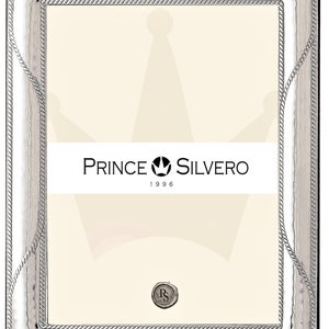 Könnte beinhalten: Silberner Bilderrahmen mit einem seilartigen Design am Rand. Der Rahmen hat eine strukturierte Oberfläche und ein silbernes Kronenlogo mit dem Text "PRINCE SILVERO 1996".