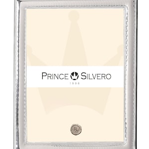 Könnte beinhalten: Silberner Bilderrahmen mit einem dekorativen Rand und einem Prince Silvero Logo mit dem Jahr 1996.