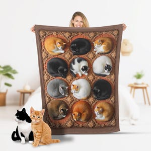 May include: A brown and tan fleece blanket with a repeating pattern of sleeping cats. The cats are in various poses and colors, including black, white, orange, and gray.
