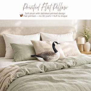 May include: A flat, soft plush pillow shaped like a Canada goose with a detailed printed design. The pillow features the text Printed Flat Pillow, Soft plush with detailed printed design, Flat printed &mdash; no 3D parts &bull; fluff to shape.