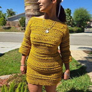 May include: A mustard yellow crochet dress with a scoop neckline and three-quarter sleeves. The dress is fitted and has a slightly flared skirt.