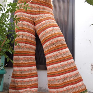 May include: Wide-leg crochet pants with a striped pattern in shades of orange, brown, green, and white.
