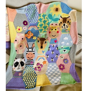 May include: A colourful knitted baby blanket with a hexagonal pattern featuring various animal faces, flowers, and other whimsical designs. The blanket is made with soft yarn in shades of pink, blue, green, yellow, and purple.