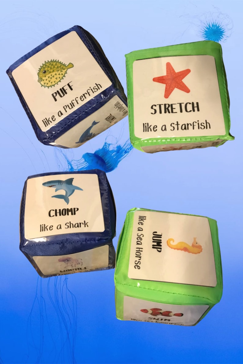 May include: Four colorful fabric dice with sea creature illustrations and action words. The dice are blue, green, and have the words "Puff like a Pufferfish", "Stretch like a Starfish", "Chomp like a Shark", and "Jump like a Sea Horse".