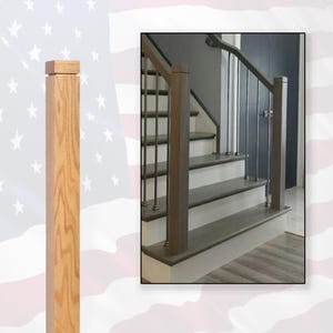 May include: A wooden stair post with a square top and a natural wood finish. The post is part of a staircase with black metal balusters and a white handrail.