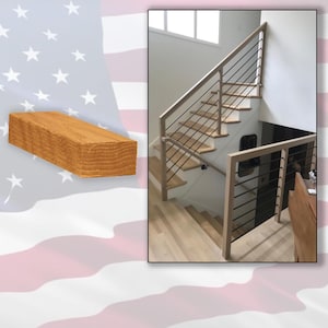 May include: A wooden staircase with light-colored wood steps and railings, featuring black metal balusters. The design includes a landing and a lower set of stairs. A rectangular wooden block is on the left side of the image.
