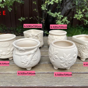 May include: Set of six white ceramic flower pots with different designs. The pots are 6.5 cm in diameter and 6.5 cm tall. The pots have a variety of floral designs and the words "Enjoy" are printed on one of the pots.