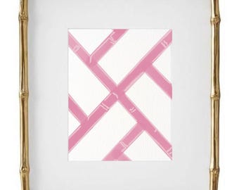 May include: A gold bamboo picture frame with a white mat and a pink and white geometric pattern print inside.