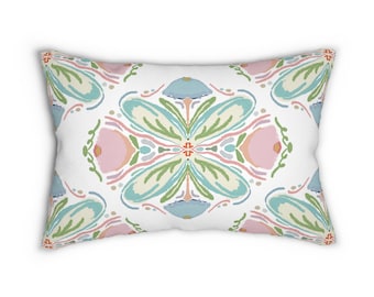 Può includere: Cuscino rettangolare decorativo con motivo floreale. Il design presenta disposizioni simmetriche di elementi floreali blu pastello, rosa e verdi su sfondo bianco. Il cuscino ha un aspetto morbido e invitante, adatto all'arredamento.