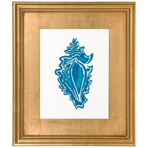 May include: A framed print featuring a stylized blue seashell design on a white background. The artwork is encased in a gold-colored, rectangular frame. The seashell illustration has a detailed, layered appearance.